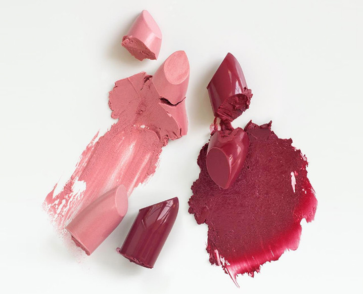 Pink and red lipstick bits with smudges on the background