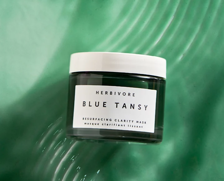 Herbivore Blue Tansy Resurfacing Clarity Mask displayed on a rippled green background.