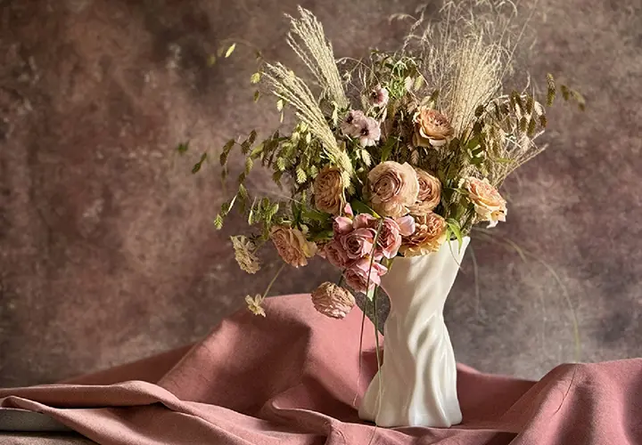 Sullivan Owen sculptural porcelain vase with a romantic floral arrangement