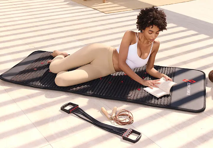 Woman relaxing on the BON CHARGE Infrared PEMF Mat Max