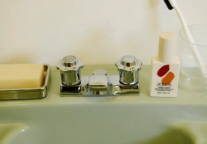 Zouck Screen Screen mineral sunscreen beside a bathroom sink